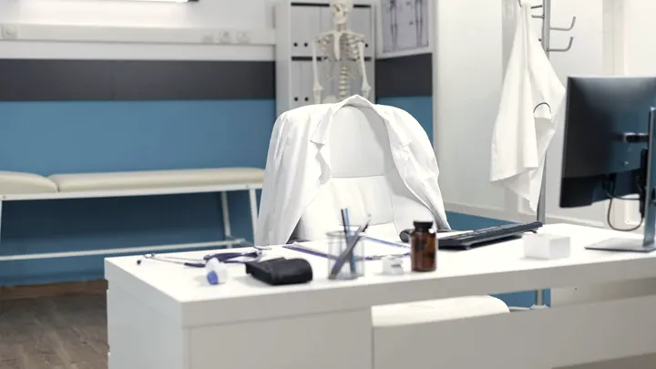 Mesa de consultório com computador, pronta para uma consulta por vídeo.