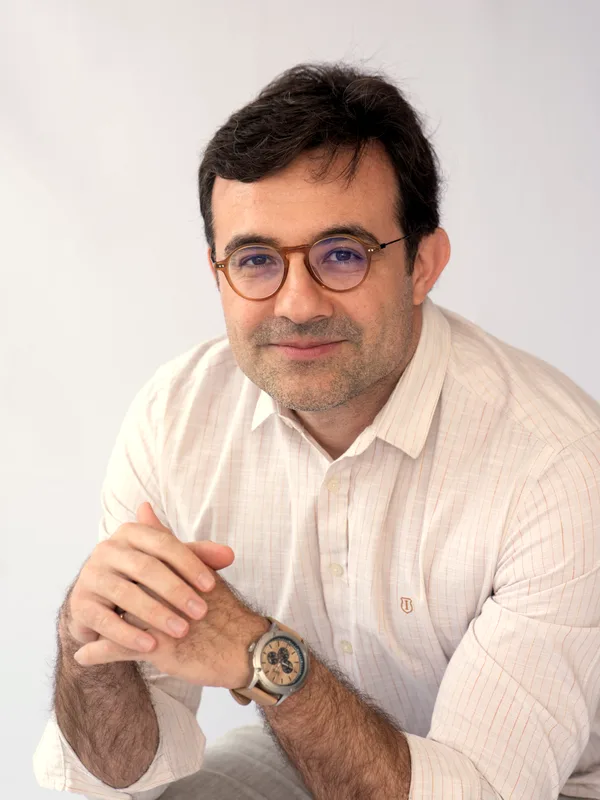Dr. Fábio Minotti, ginecologista e obstetra, sentado em retrato de consultório